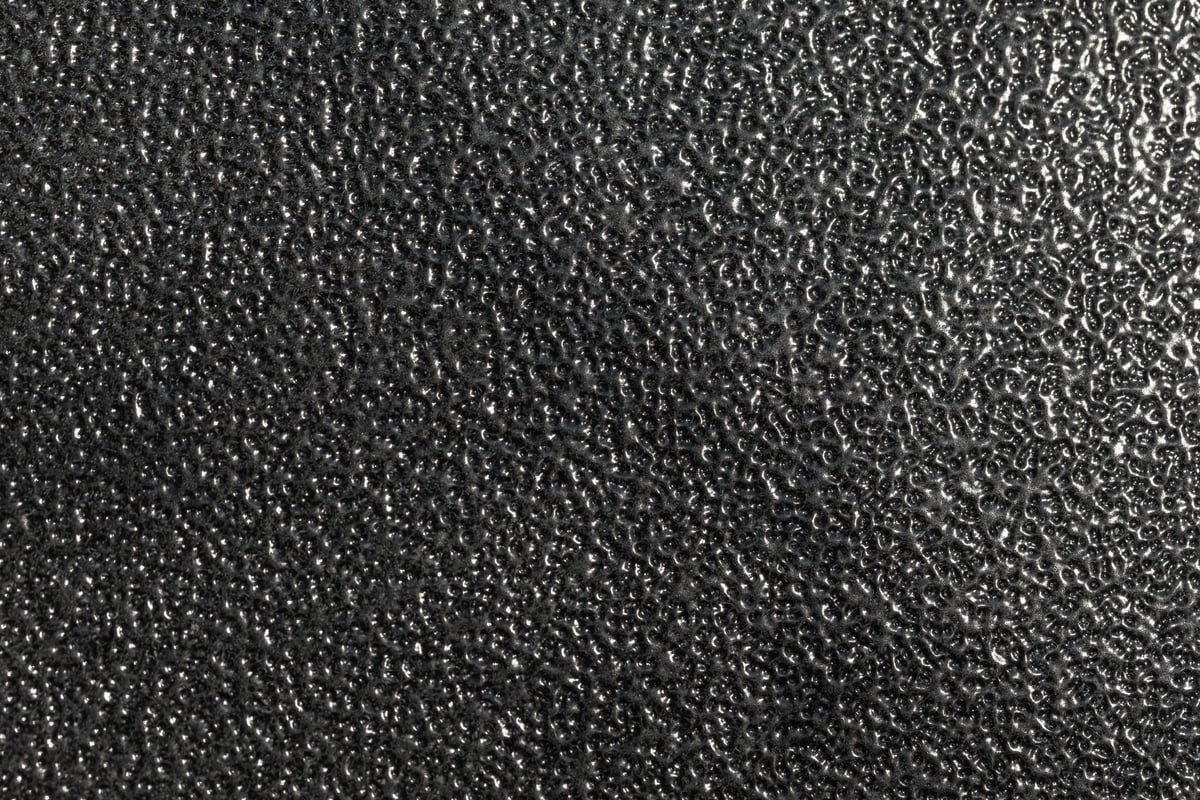 Close-up of a steel surface with a glossy black powder coated finish